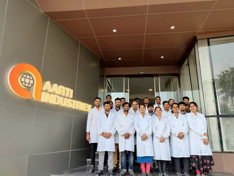 Diverse team of Aarti Industries employees posing together in professional corporate setting