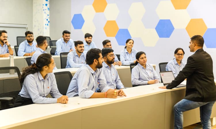 Female employees of Aarti Industries in blue uniforms standing together in landscaped area